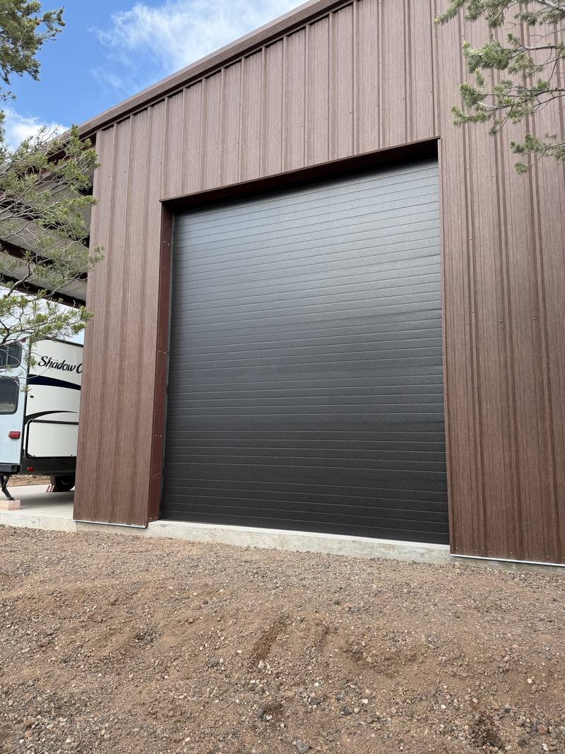 Newly installed rolling steel garage door on a metal building, installed by Venture Doors